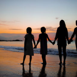 Family silhouette in the sunset on beach vacation